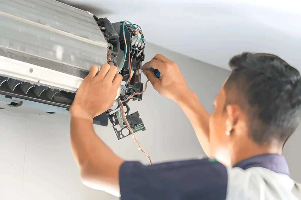 AC technician repairing air conditioner in Dubai home